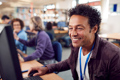 Modern Practical Learning man using a computer in an group office