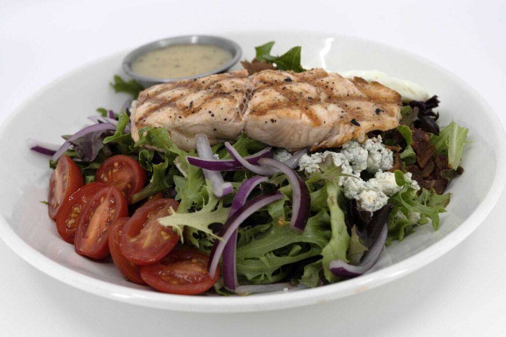 Chicken salad with tomatoes and onions, dressing and blue cheese.