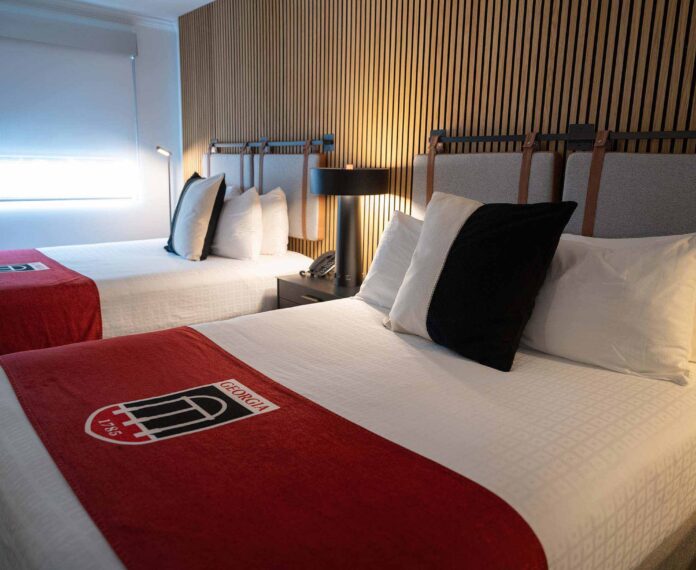 Angled view of two queen beds in a room with a black and white pillows