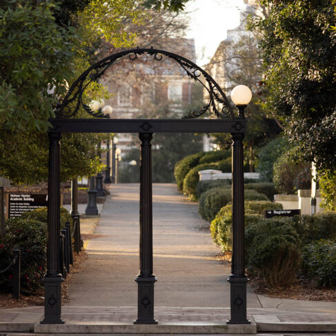 The Arch is highlighted by early morning sunlight with North Campus in the background.