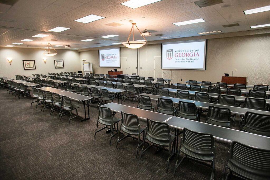 View inside of Conference room K/L with projection screens, tables and chairs lined up and ready.