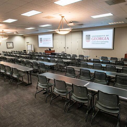 View inside of Conference room K/L with projection screens, tables and chairs lined up and ready.
