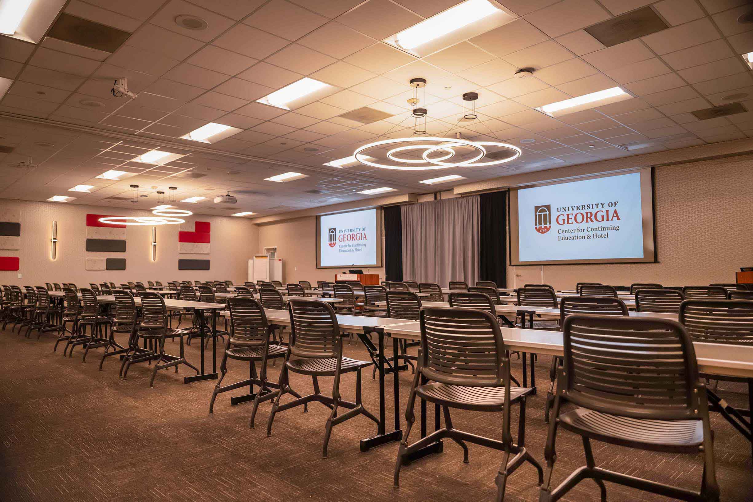 View inside of Conference room K/L with projection screens, tables and chairs lined up and ready.