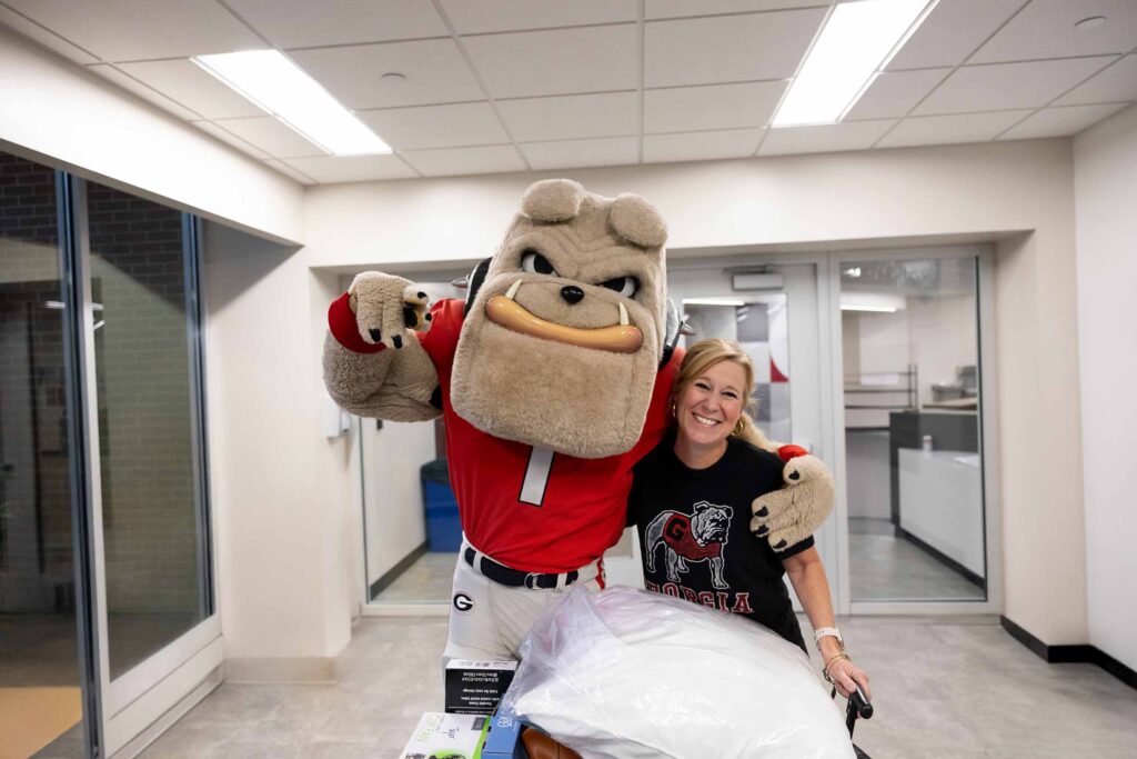 Hairy Bulldog standing with a student that is moving into a dorm