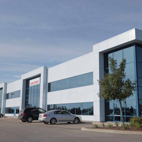 VIew of commercial real estate building with 4 cars in front.