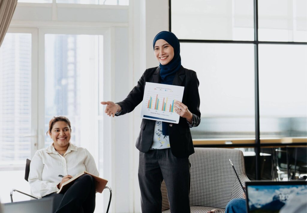 A female business entrepreneur holding research data and presenting to her team in office