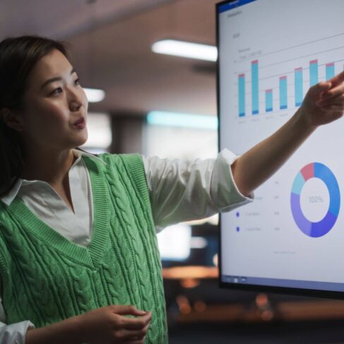 Portrait of A Female Presenting Financial Goals For Marketing Strategy, Uses TV Set with Data Analysis, eCommerce Infographics