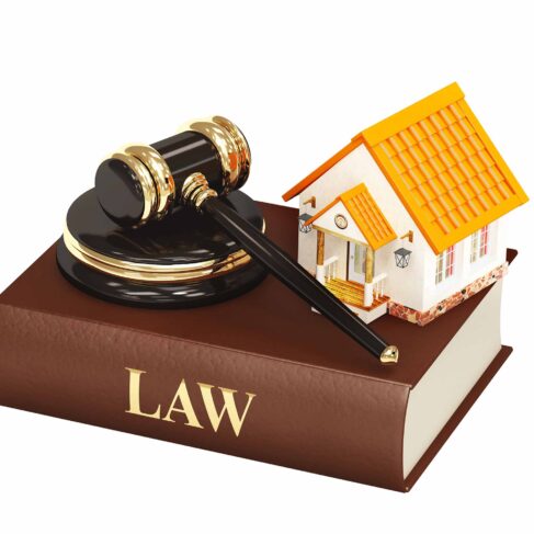 Miniature House and judge gavel on top of a law book.