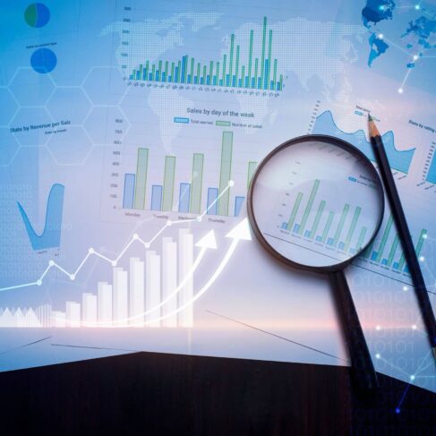 Magnifying glass and documents with analytics data lying on table , and digital virtual reality graph