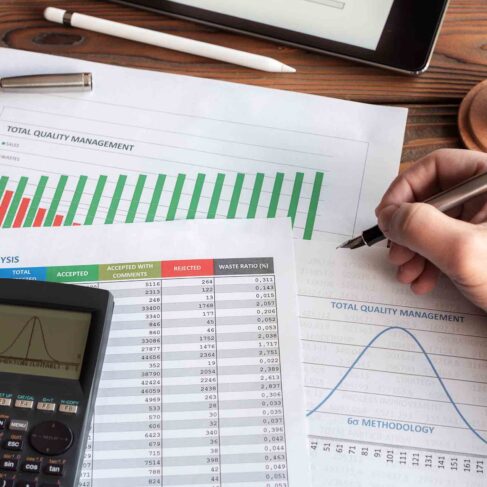 Total Quality Management, Lean Production Analysis and Six Sigma Methodology Graphics on Work Desk