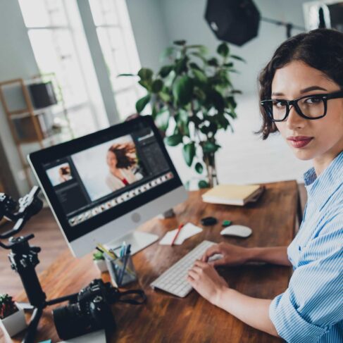 Photo of a photographer editing portraits on her computer.