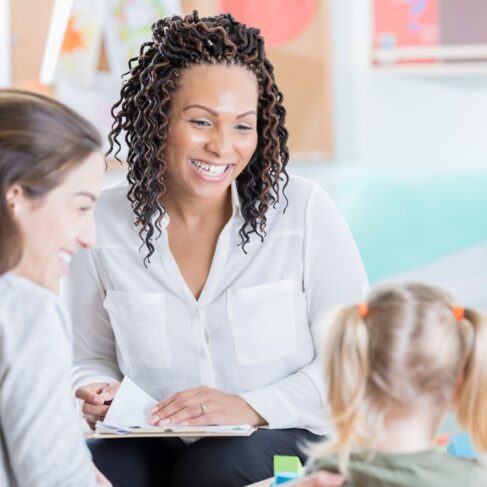A mom participates in a parent teacher conference with her daughter's preschool teacher.
