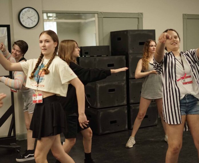 five students standing in a room