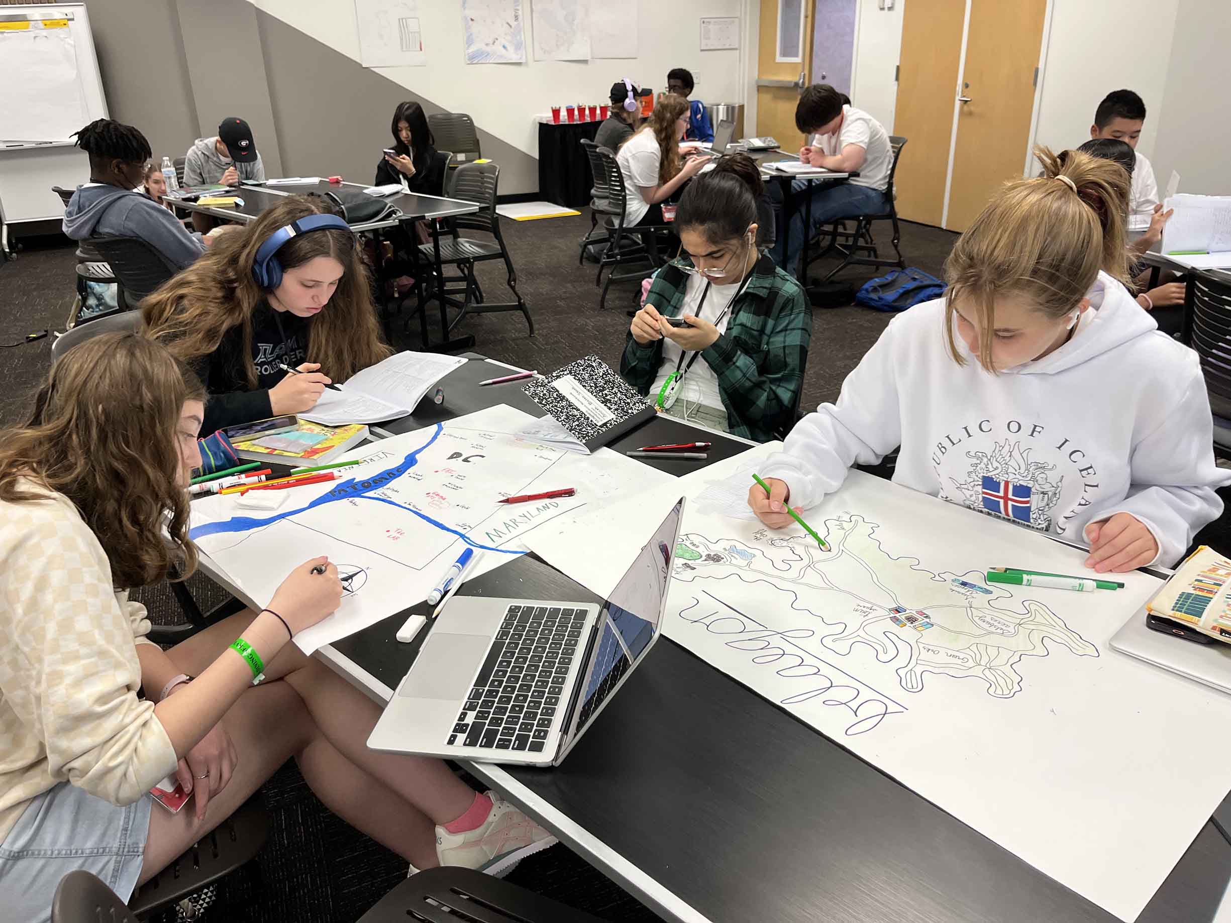 three students sitting at a table with papers