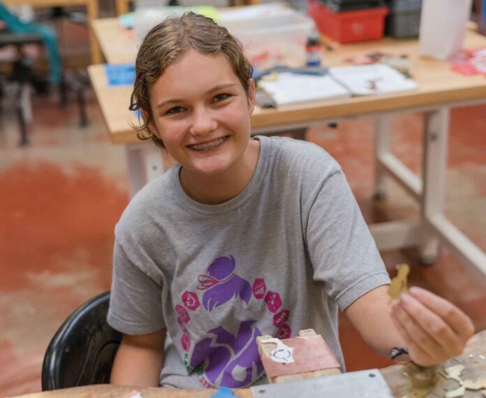 student holding a piece of metal