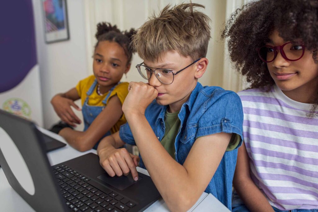 Group of primary school students using laptops in the school