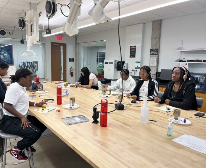 Six students working on an engineering project in a classroom.