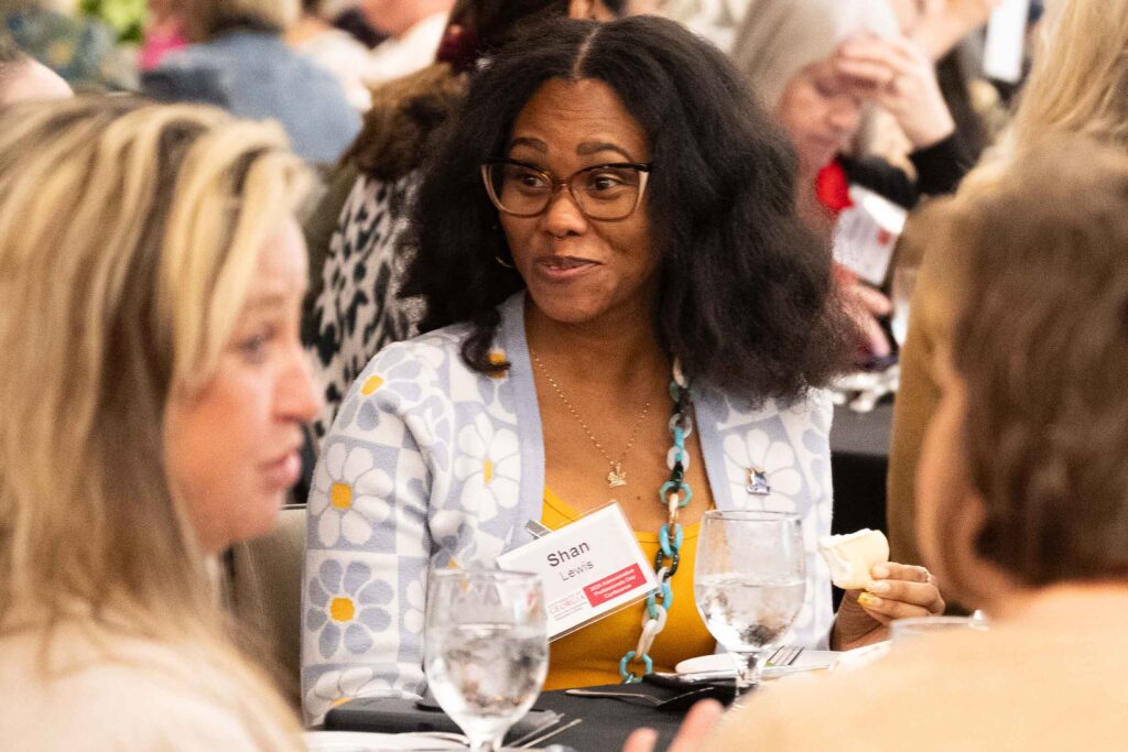 Shan L. talking to a participant at a conference