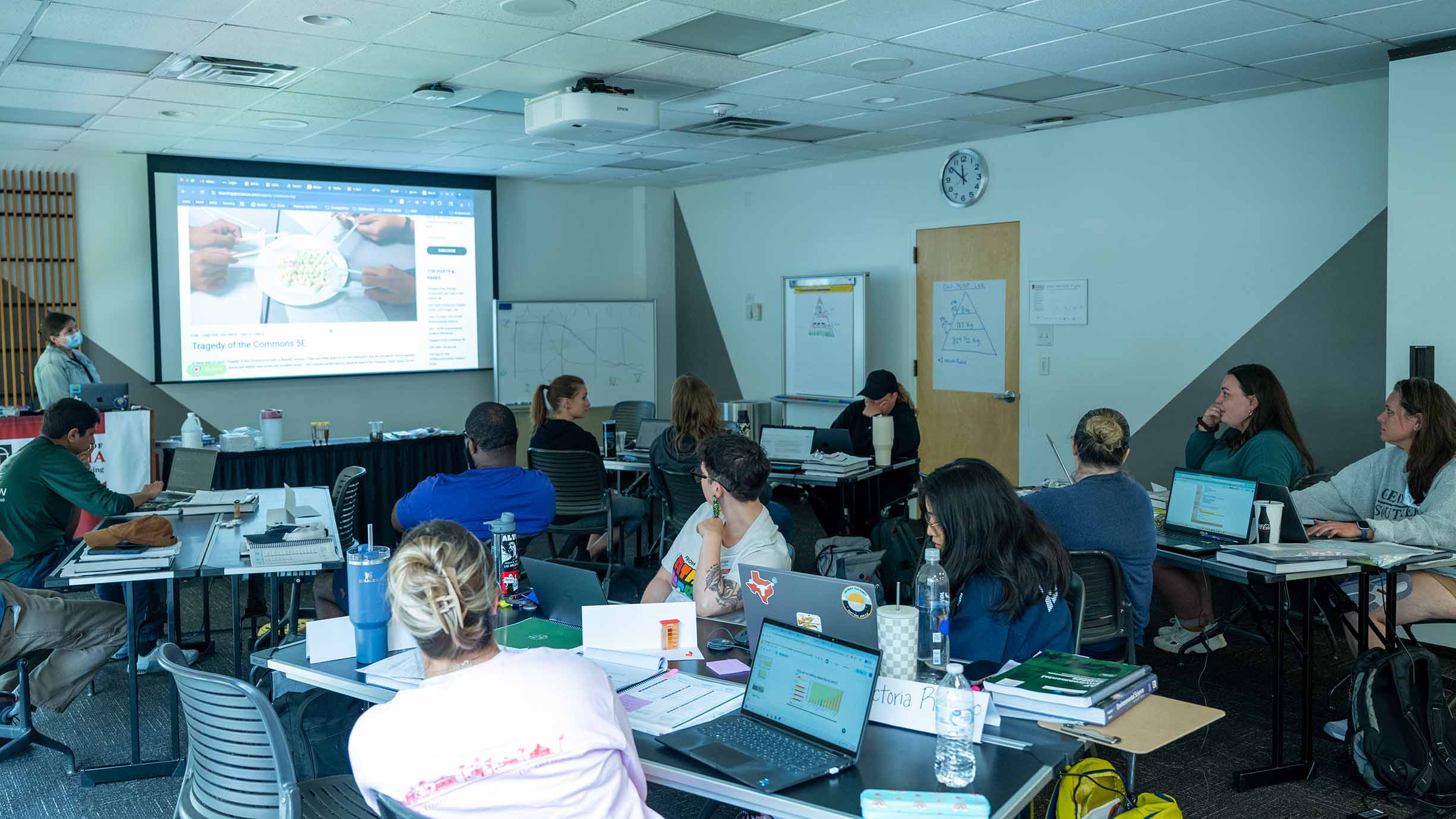 Classroom full of students looking a presentation on a screen.