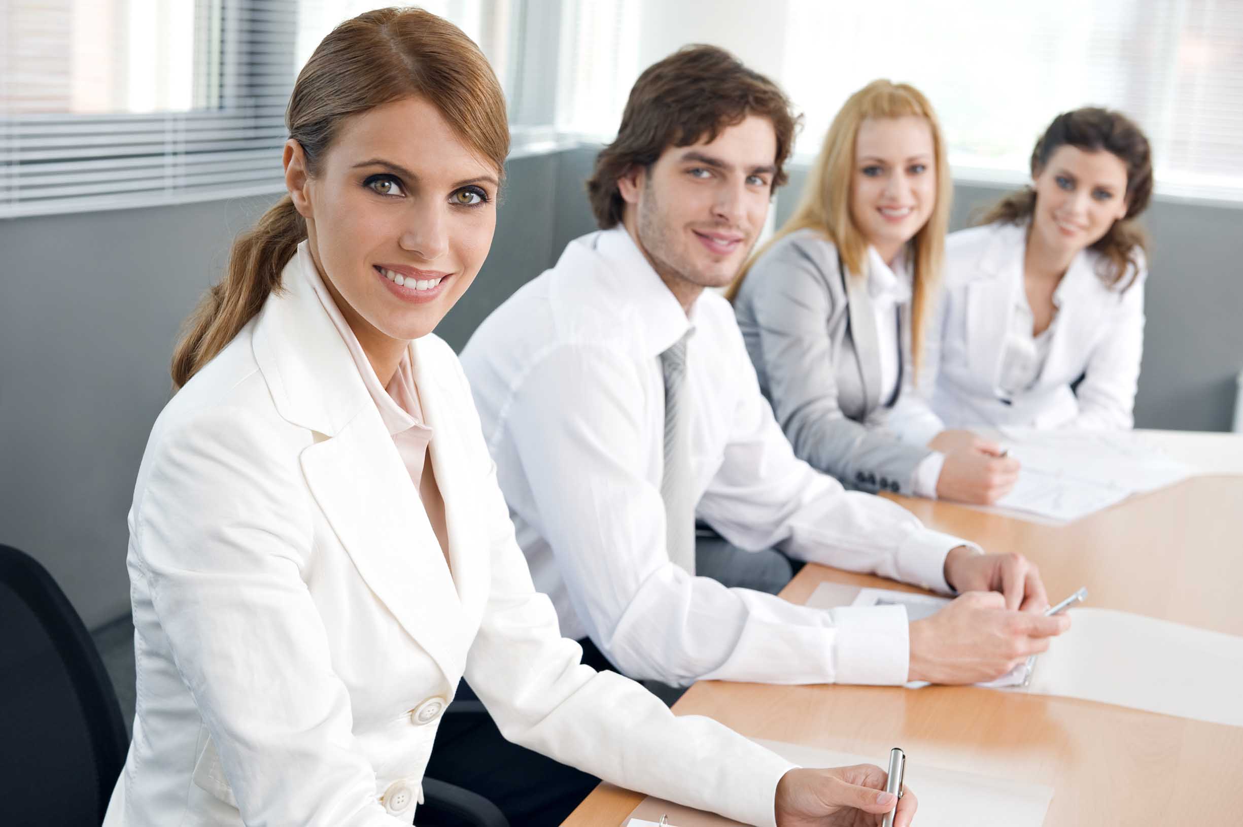 Four business colleagues sitting in a row and working together on a business presentation.