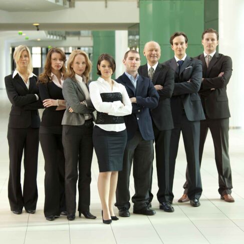 Group of business people standing in a hallway.