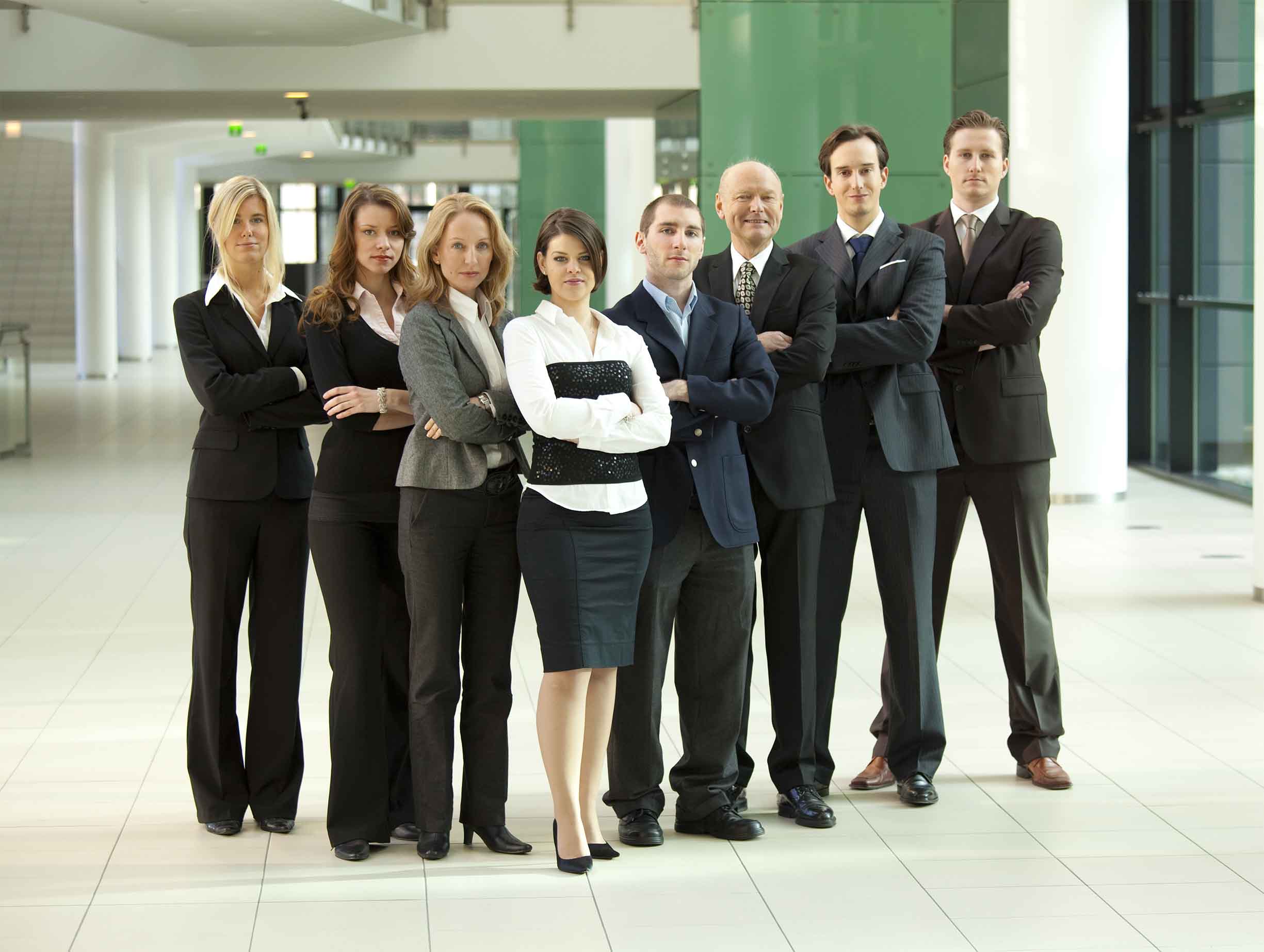 Group of business people standing in a hallway.