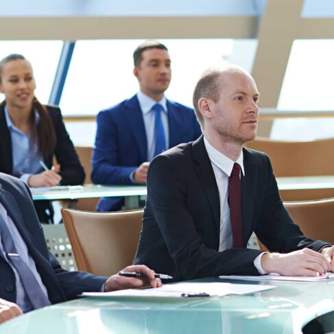 Business people listening to presentation at conference
