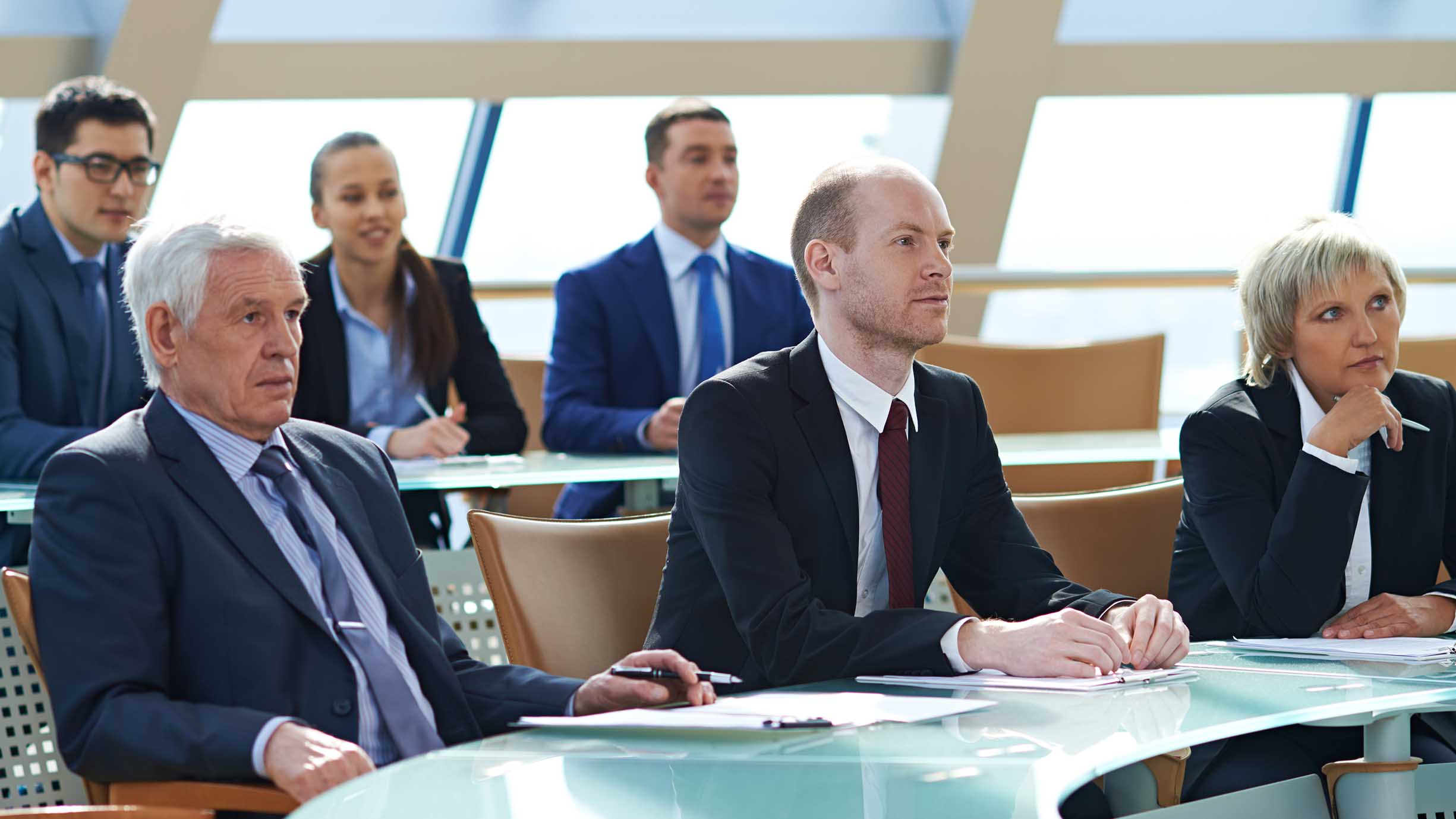 Business people listening to presentation at conference