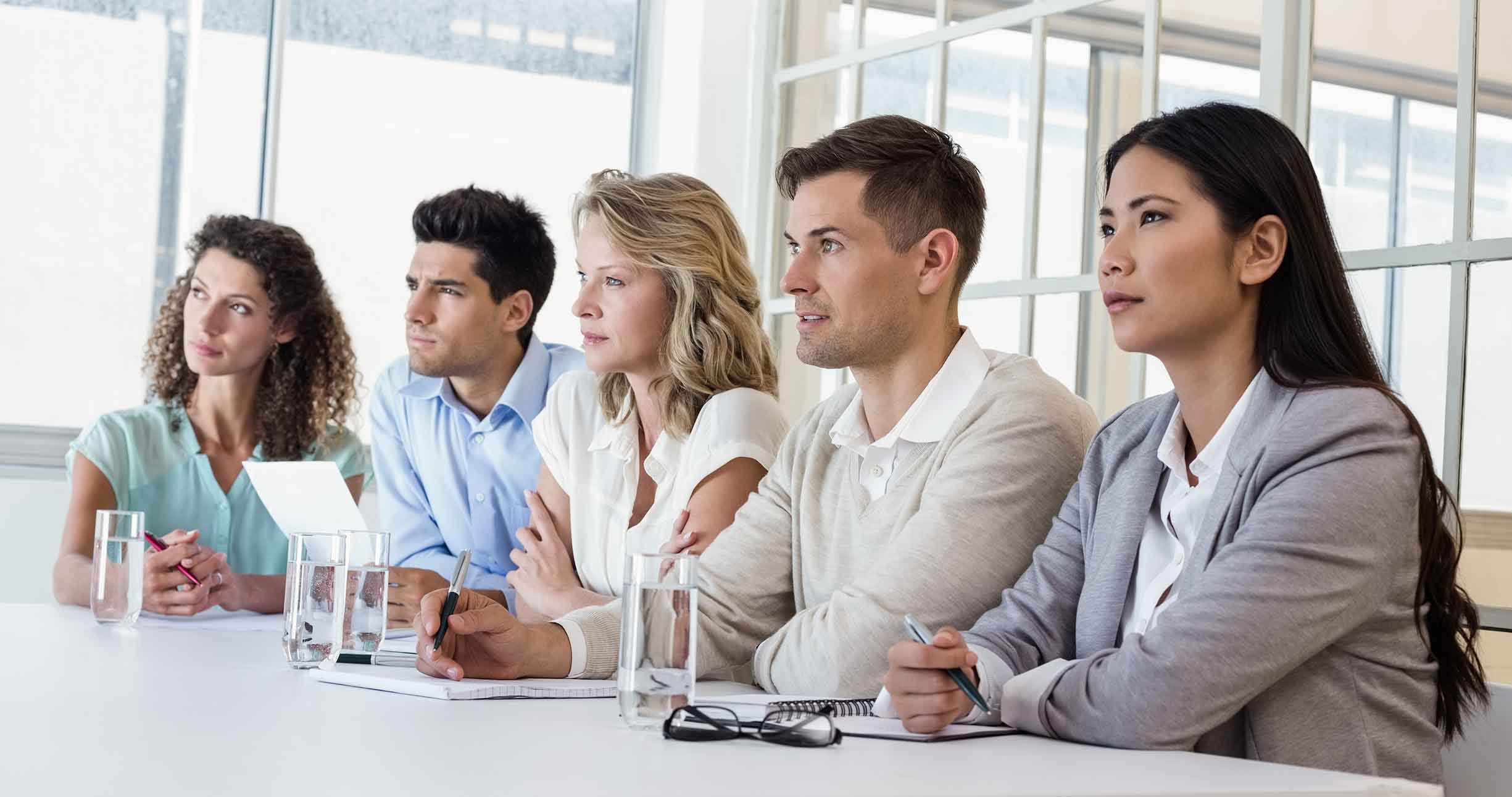 Casual business team listening during meeting in the office