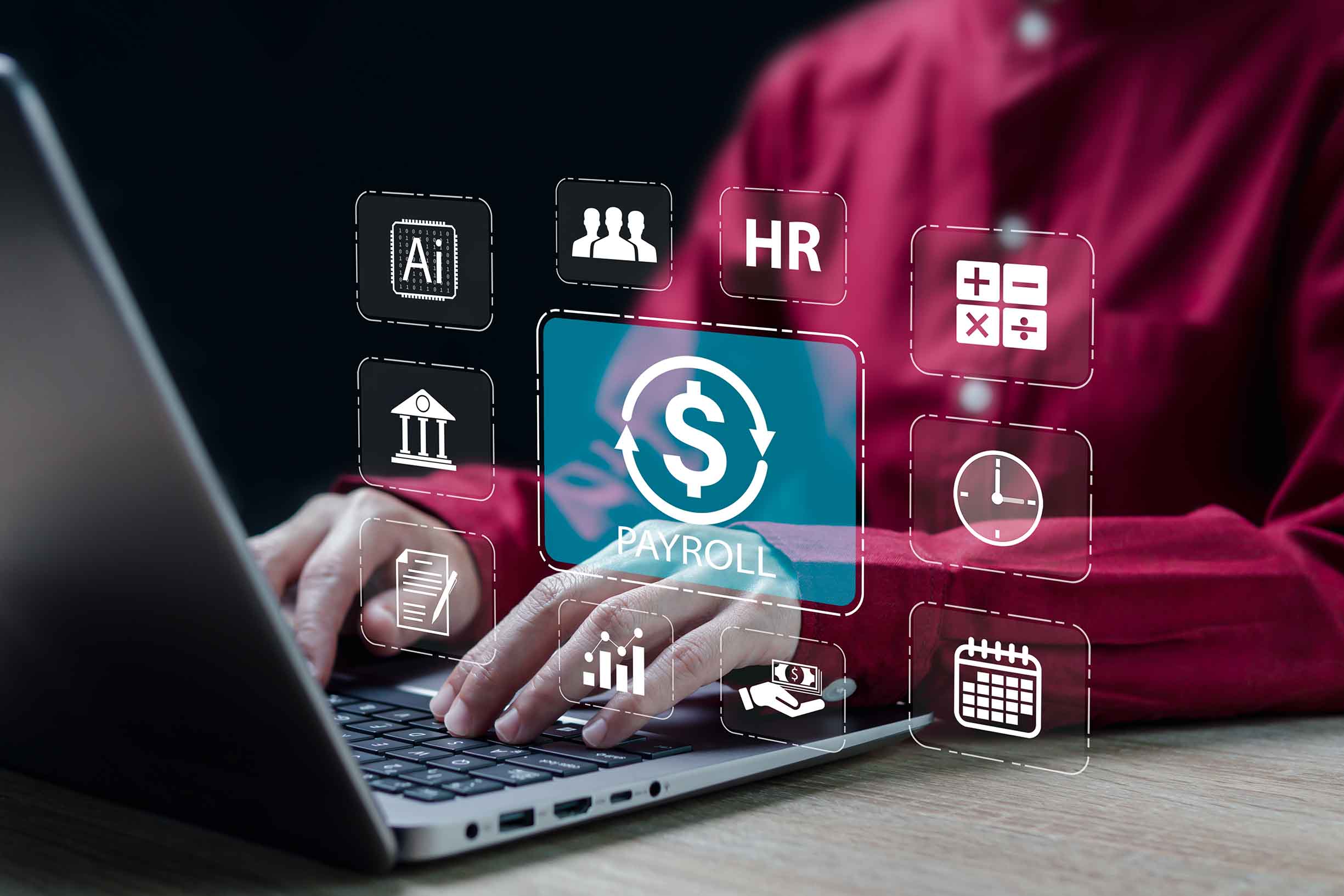 A person holding payroll of the company by using a computer with icons floating over the keyboard.