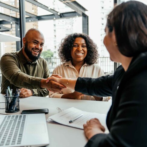 Couple closing real estate contract with real estate agent