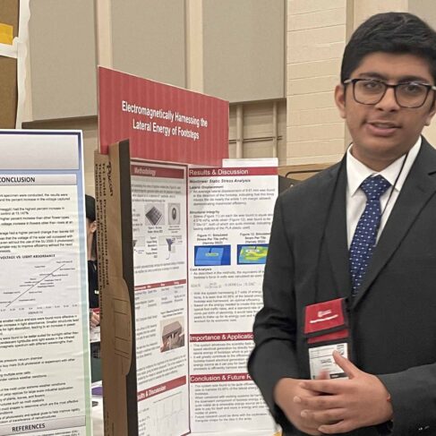 Student standing next to his project