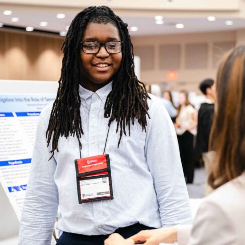 A science fair student explaining his project to a judge