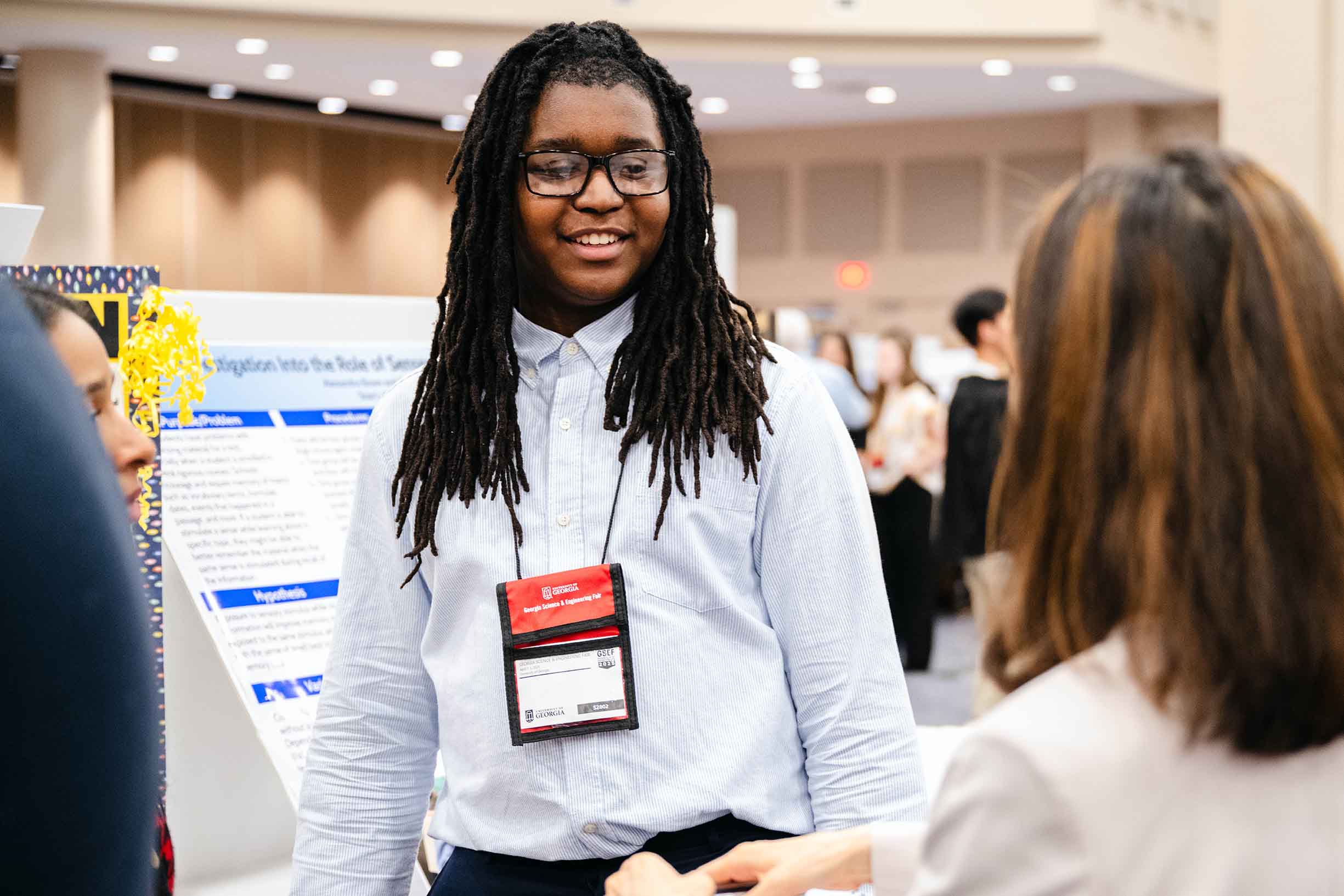 A science fair student explaining his project to a judge