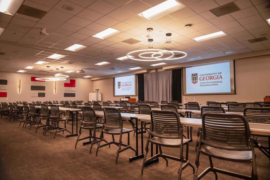 View inside of Conference room K/L with projection screens, tables and chairs lined up and ready.
