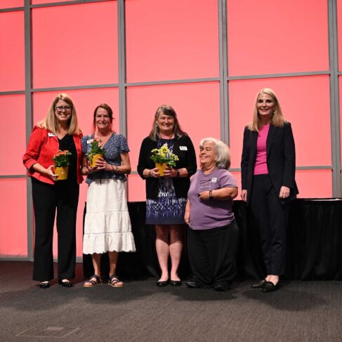 Georgia Center employees standing on a stage receiving awards.