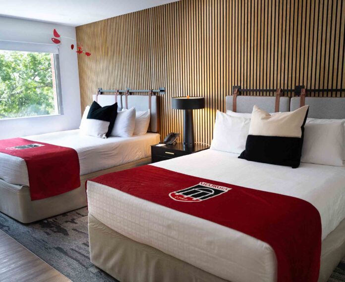 Angled view of two queen beds in a room with a black and white pillows