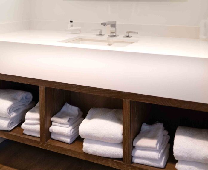 Bathroom sink with towels in the Alumni Queen Suite