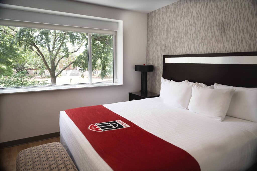 Dean’s King Suite Bed with a view of a tree outside the window