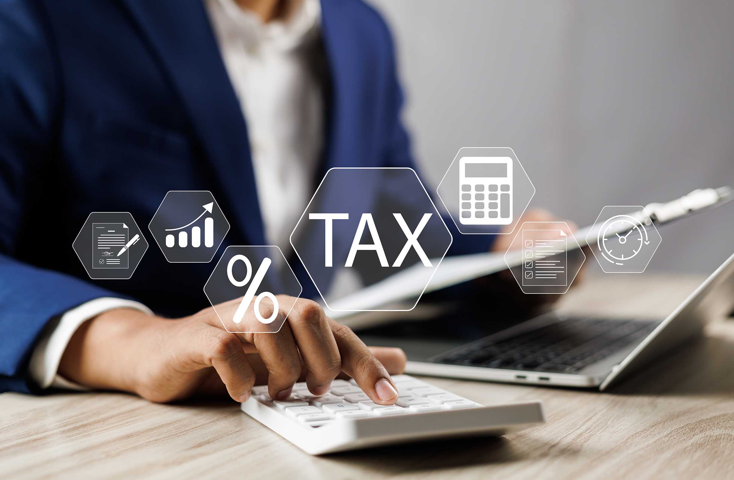 Businesman using calculator and laptop to complete Individual income tax return form online for tax payment.