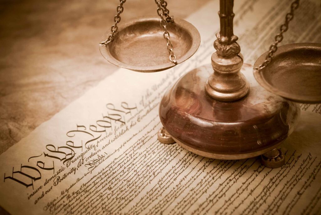 Constitution and scales of justice in sepia tone with vignette added for aged antique style.