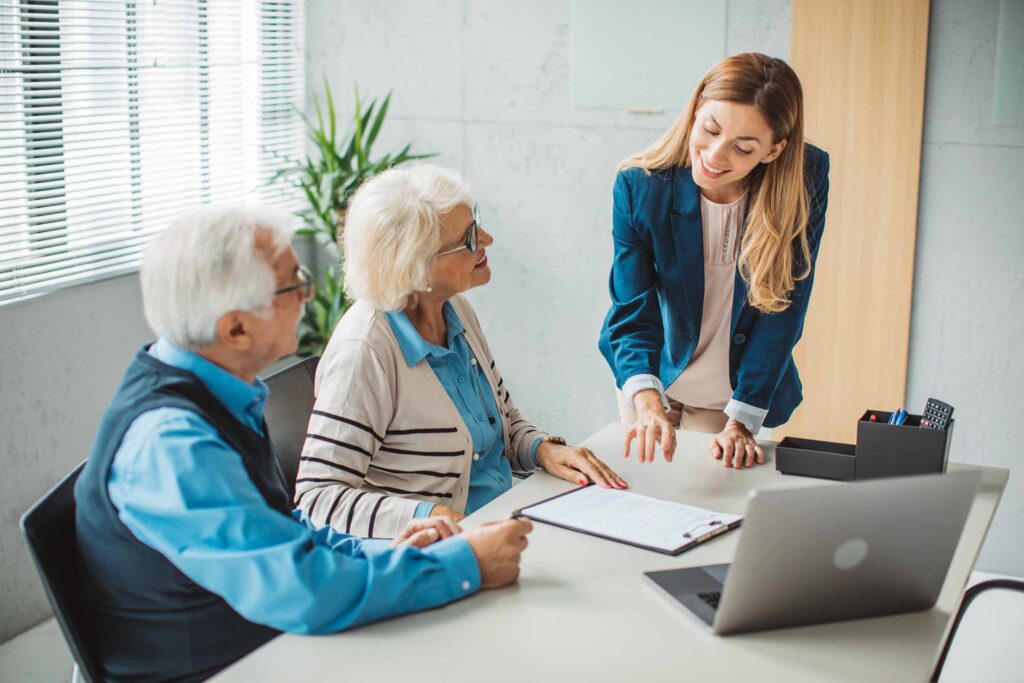 Senior couple talking with female paralegal at the office.