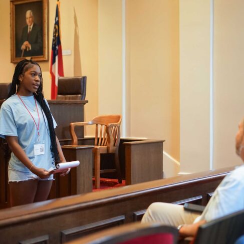 Student standing a courtroom speaking to a jury.