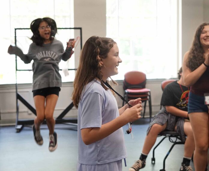 Three female students acting in a classroom.