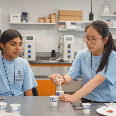 Two students in a engineering lab working on a project.