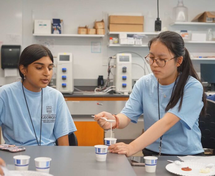 Two students in a engineering lab working on a project.