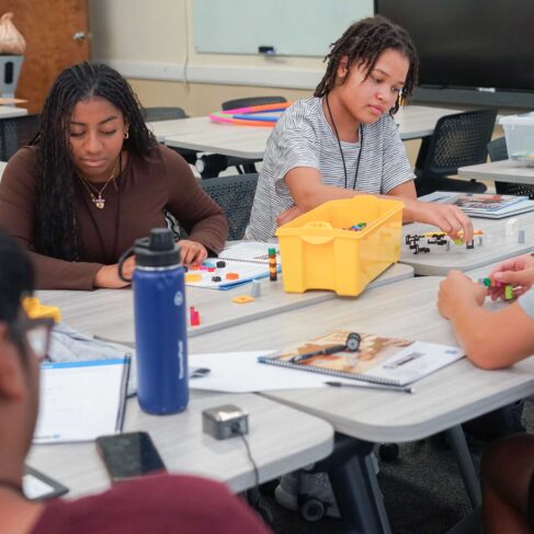 Four students using Lego's to learn about financial planning