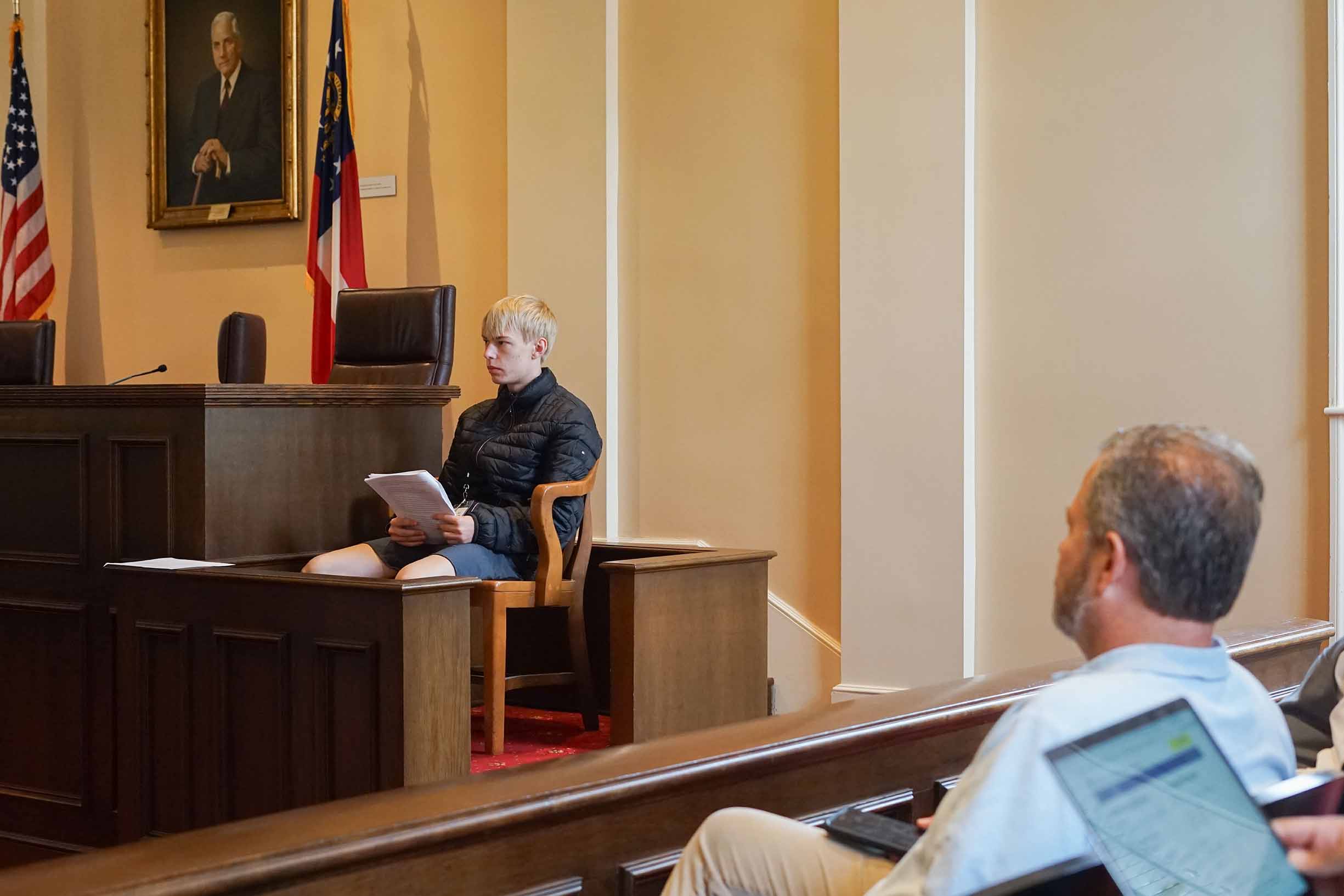 A student sitting in the witness stand in a mock trial