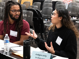 Two judges sitting at a table having a discussion.