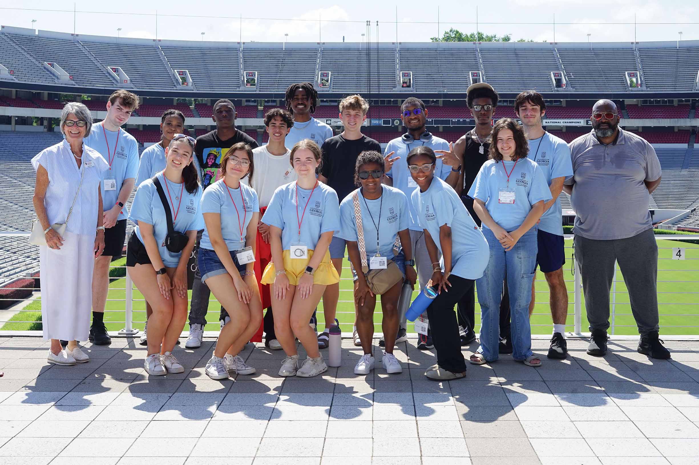 students standing in front of the University of Georgia football stadium